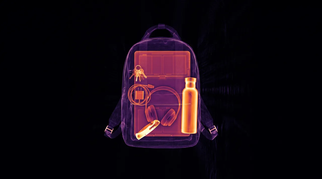 The same backpack scanned: a laptop, a bottle, keys, headphones, a charger and a folding knife inside.